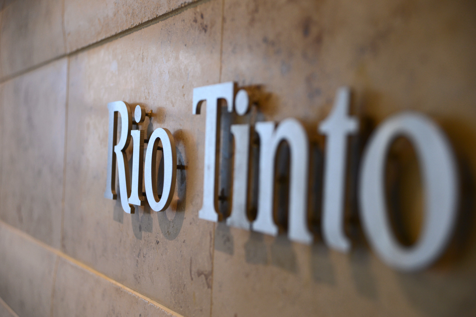 The Rio Tinto Group logo is mounted on a wall near the reception area of the company's offices in Melbourne, Australia, on Thursday, Feb. 28, 2013. Rio Tinto, the world's second-biggest mining company, named non-executive board director Christopher Lynch as chief financial officer to replace Guy Elliott who announced his retirement in July. Photographer: Carla Gottgens/Bloomberg via Getty Images